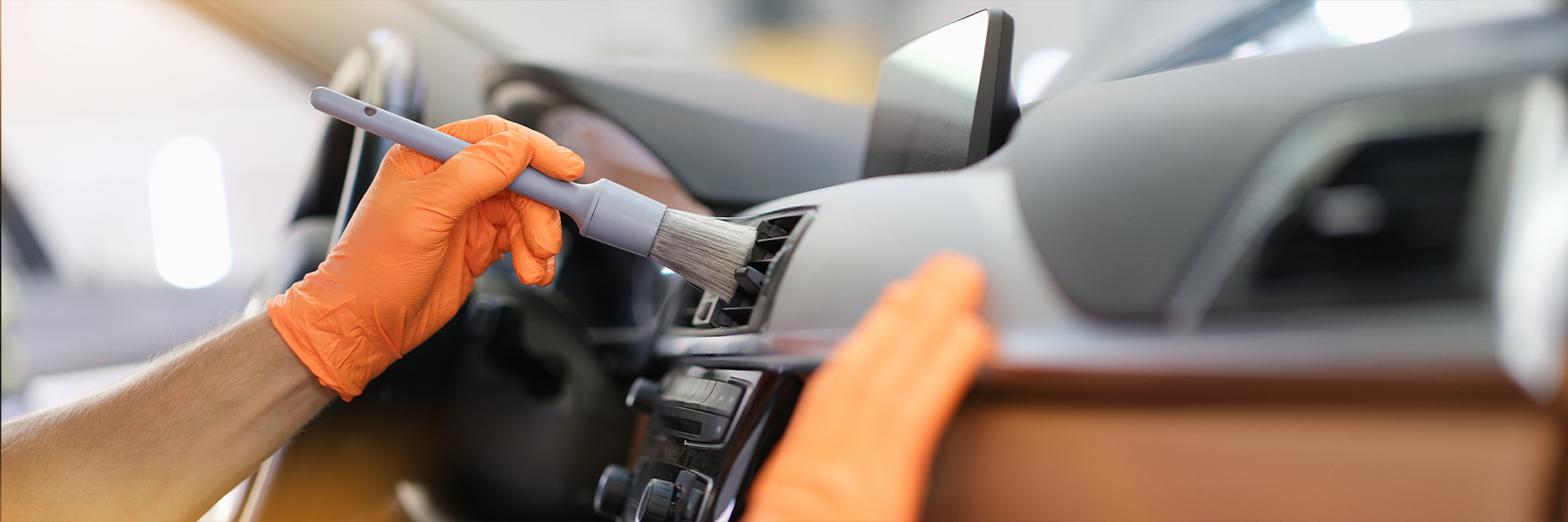 Männliche Hand hält graues Rouge in orangefarbenen Schutzhandschuhen Männliche Hand hält graues Rouge in orangefarbenen Schutzhandschuhen