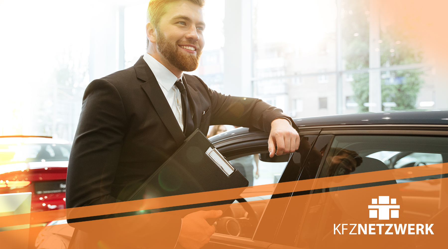 Automobilkaufmann bei seiner Beratung Automobilkaufmann mit Akten an der Hand und an einem Fahrzeug angelehnt. Orangefahriger Streifen mit KFZ-NETZWERK Logo