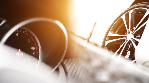 Abstraktes Foto zeigt Tacho und Reifenfelgen eines Automobils.