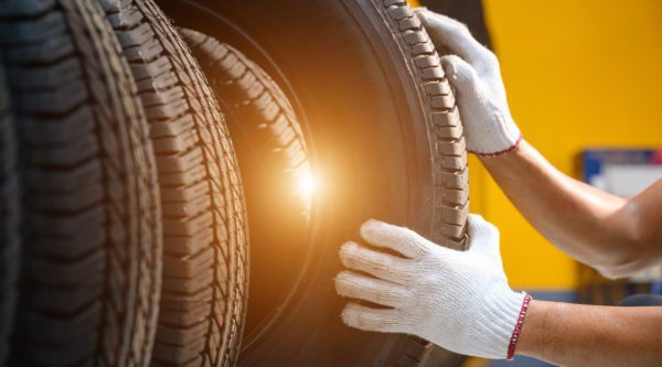 Reifenmonteur prüft den Zustand der neuen Reifen auf Lager, damit sie in einem Servicecenter oder einer Autowerkstatt ausgetauscht werden können