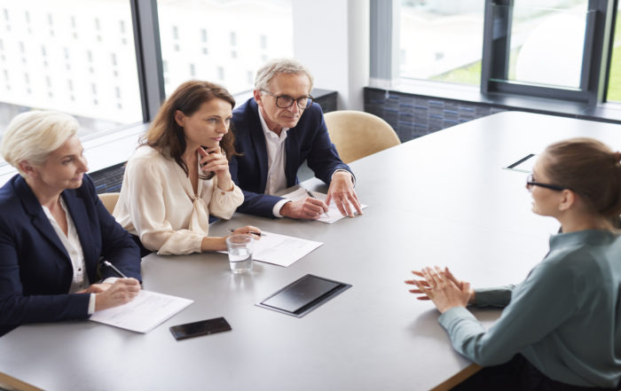 Bewerberin bei einem Vorstellungsgespräch und drei Mitglieder des Managements