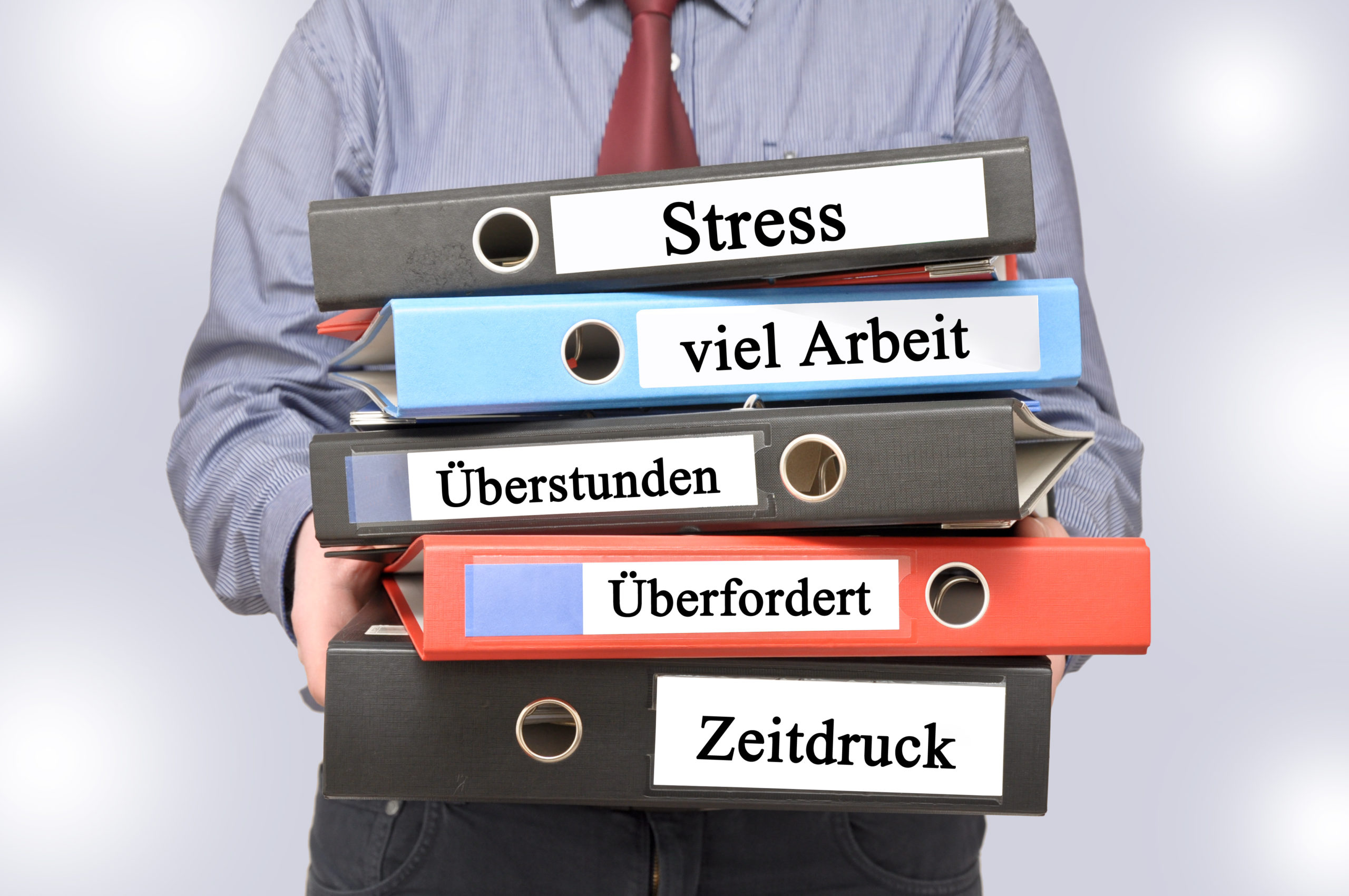 EIne Person hält fünf Ordner in den Händen