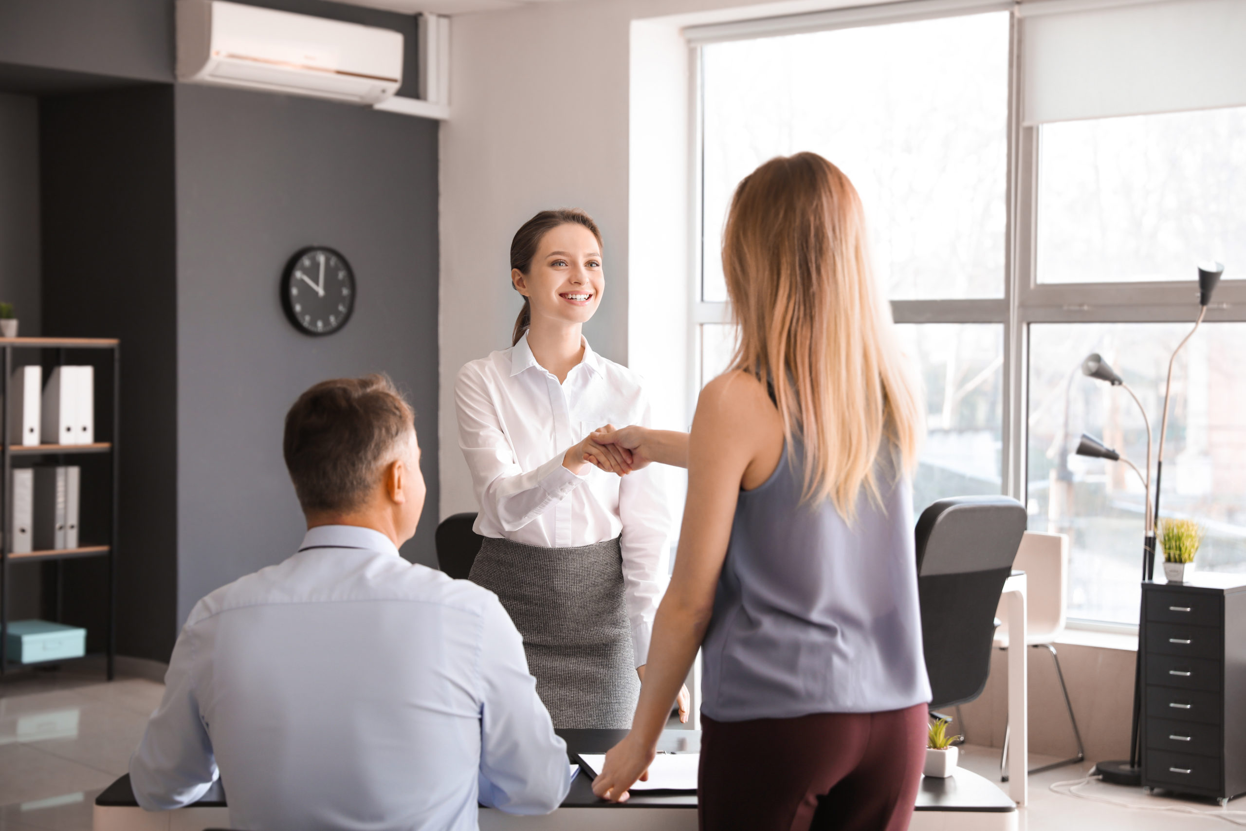 Human resources manager shaking hands with applicant after succe