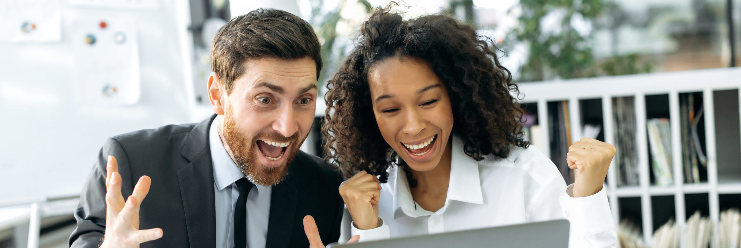 Contract signing. Successful multiracial colleagues work in a modern office on a project, have a good working deal, sign a good contract, rejoice at a job well done, gesticulate with fists, smile